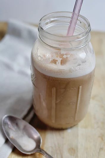 glass of chocolate milk on a wooden counter 