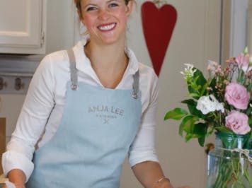 woman smiling in a blue apron