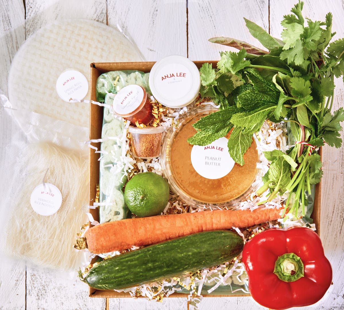 an opened box with vegetables and packages food in it