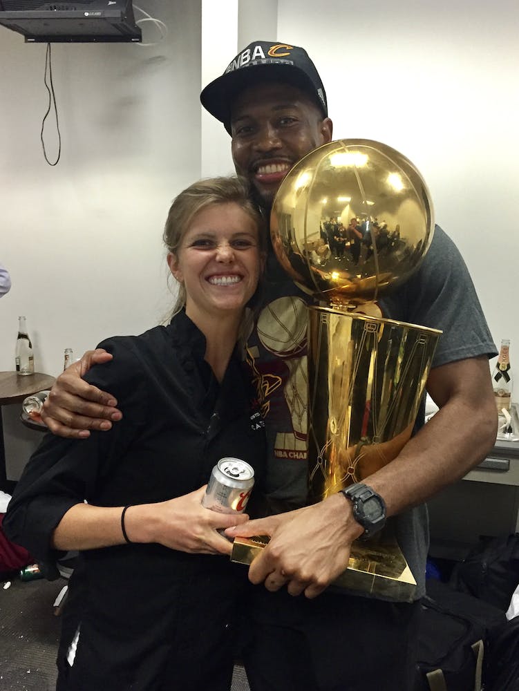 Chef Anja next to a basketball player with a basketball trophy