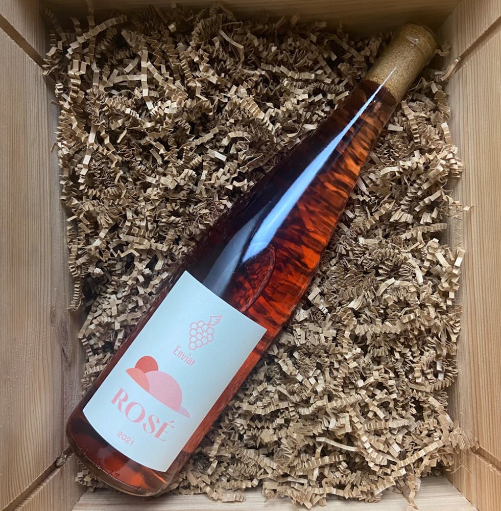 a bottle of rose laying on brown packaging