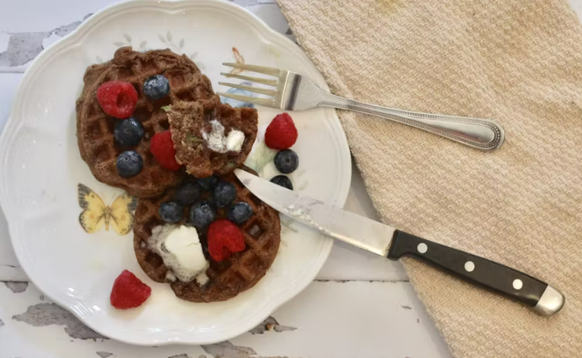 zucchini waffles on a white plate topped with berries